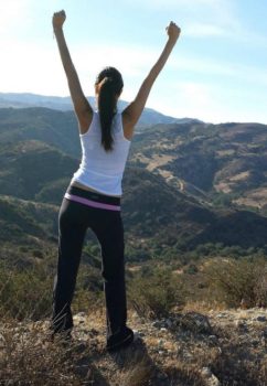 young woman standing on mountain top